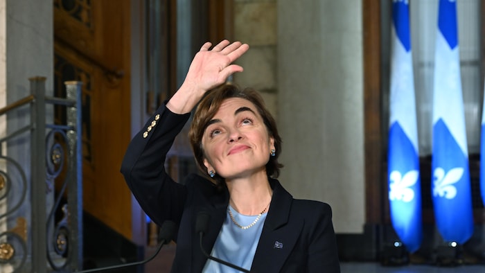 Christine Fréchette salue des observateurs sur le balcon au-dessus d'elle.