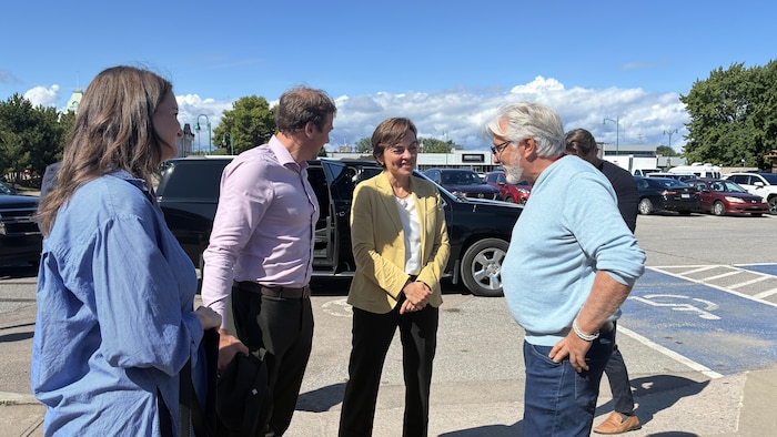La première ministre discute avec des gens dans le stationnement de la marina de Roberval.
