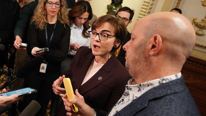 La ministre québécoise de l'Immigration, Christine Fréchette, entourée de journalistes durant un point de presse.