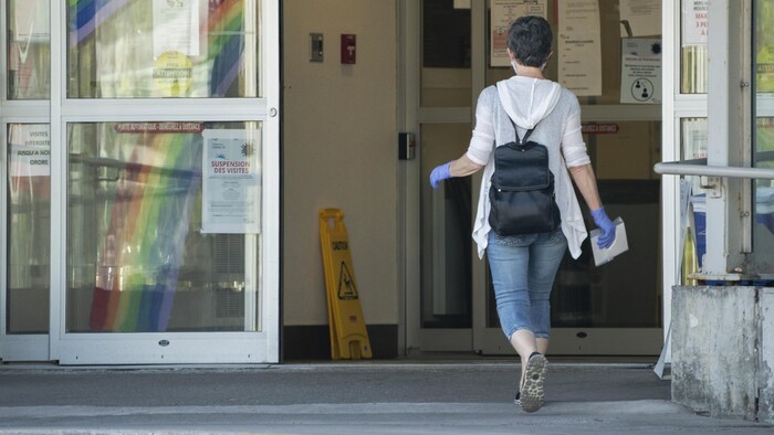 Une femme entre dans un établissement.