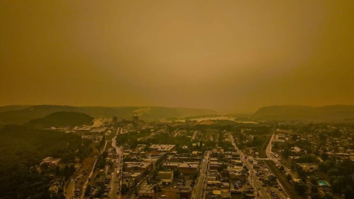 Vue aérienne de La Tuque dont le ciel est assombri par la fumée. 