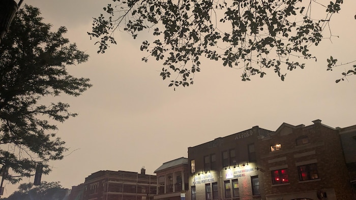 Un ciel orange et une rue commerçante.