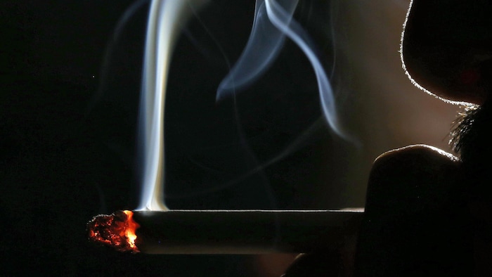Un homme qui fume une cigarette.