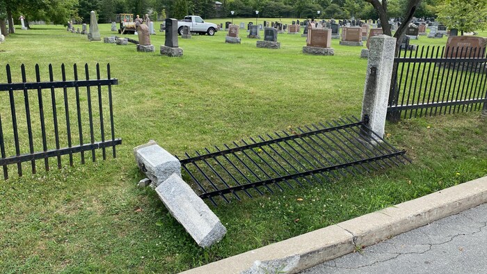 Une clôture de cimetière à terre. 