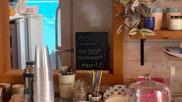 Une affiche au café CindyHook indique que l'argent comptant et la carte de débit seulement sont acceptés.