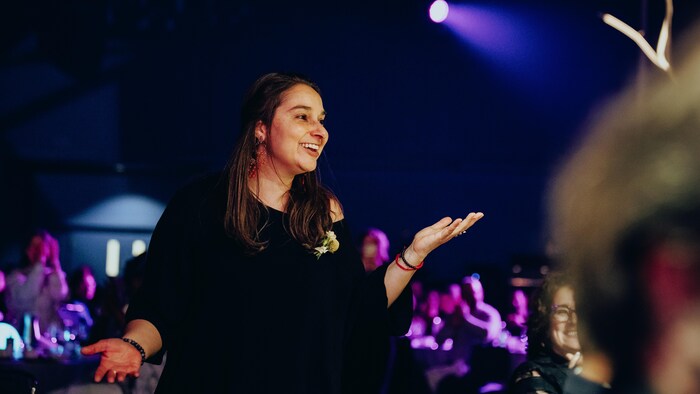 Une femme arbore un large sourire.