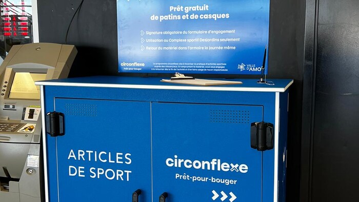 Une armoire bleue identifiée au programme Circonflexe - prêt-pour-bouger sur laquelle il est écrit Articles de sports et le logo de Loisir et Sport Abitibi-Témiscamingue.