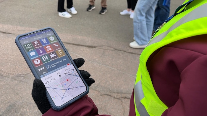 Une personne qui tient un téléphone.