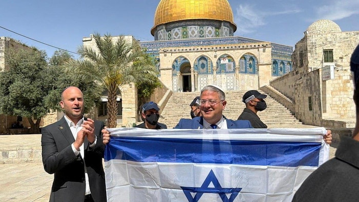 Le ministre israélien Itamar Ben-Gvir brandissant un drapeau israélien devant le dôme du Rocher.