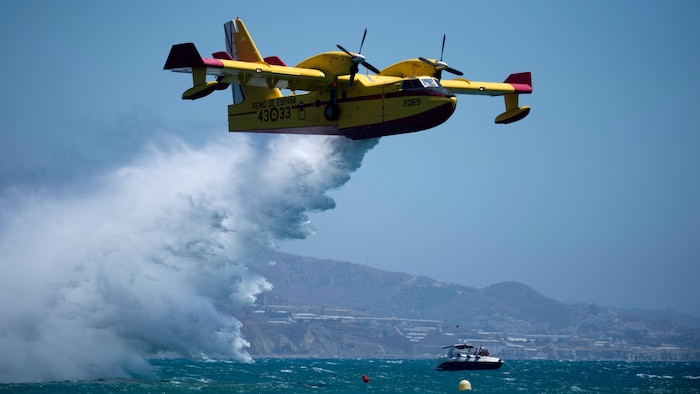 Un avión Canadair CL-215 vuela y deja caer agua. 