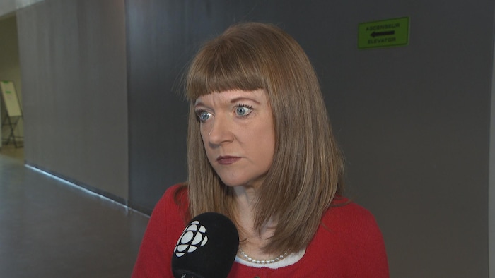 Une femme en entrevue parle au micro.