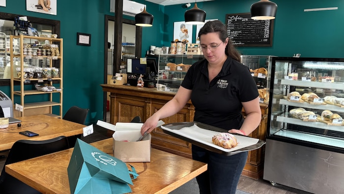 Claire Moineau sert un scone dans une boîte.