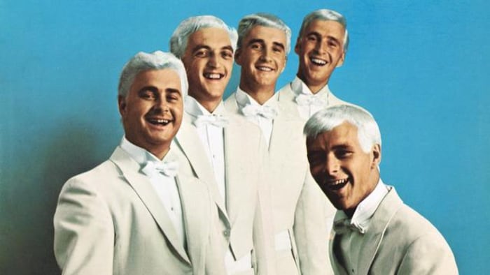Les cinq membres du groupe Les Classels dans leurs habits et perruques de scène.