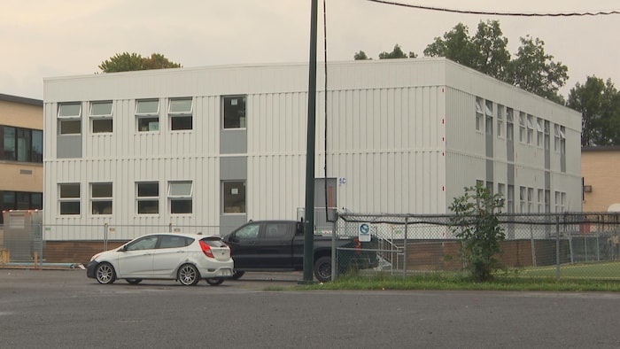 Des locaux modulaire à côté d'une école primaire.