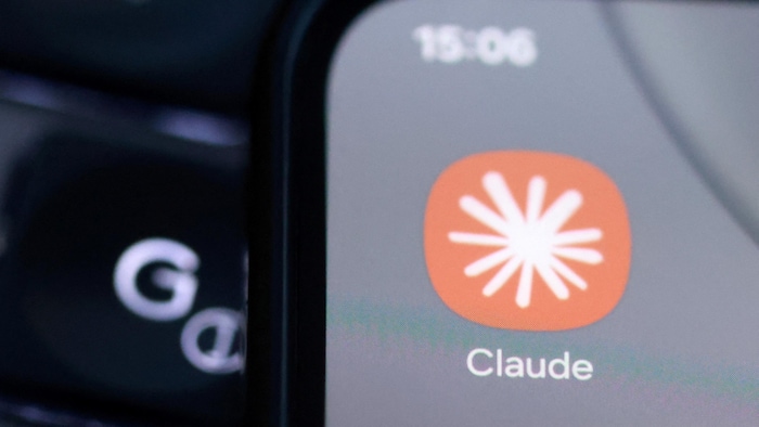 Un astérisque blanc sur un fond orange avec le mot Claude en dessous.