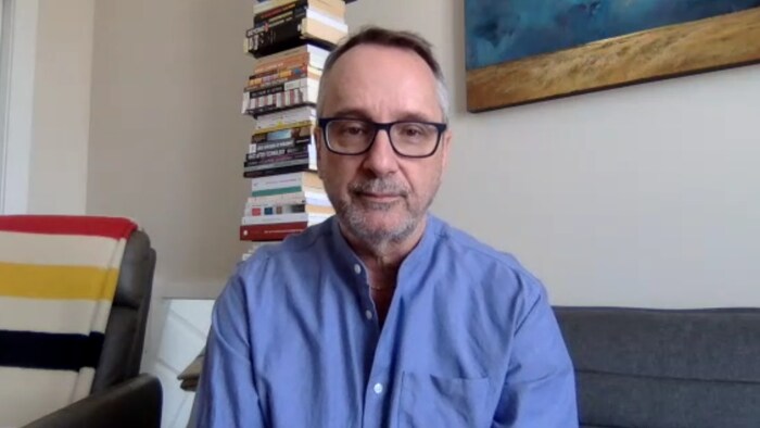 Claude Denis en entrevue assis dans son salon.