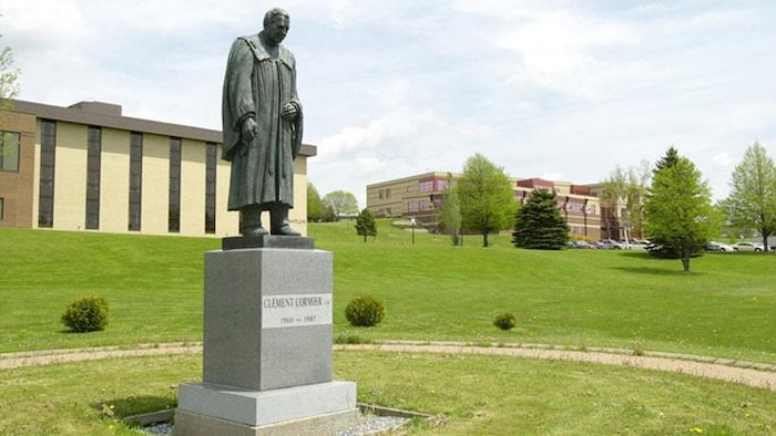 Une sculpture d'un homme devant un bâtiment.