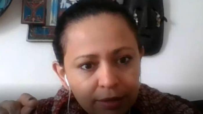 Une femme avec un écouteur blanc dans une oreille pendant une entrevue.