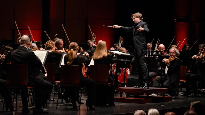 Un homme dirige un orchestre.