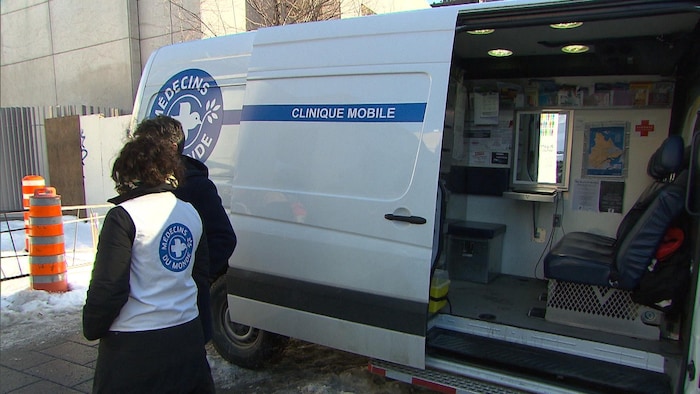 Des bénévoles de Médecins du monde Canada discutent à côté de la camionnette qui fait office de clinique mobile.