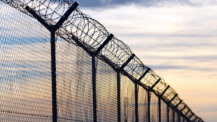 Une clôture en fil de fer barbelé d'une prison.