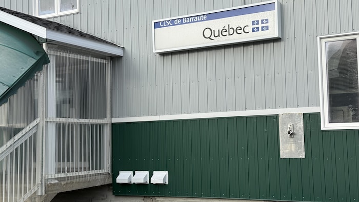La façade d'une édifice arbore une affiche sur laquelle il est écrit CLSC de Barraute avec le logo du gouvernement du Québec.