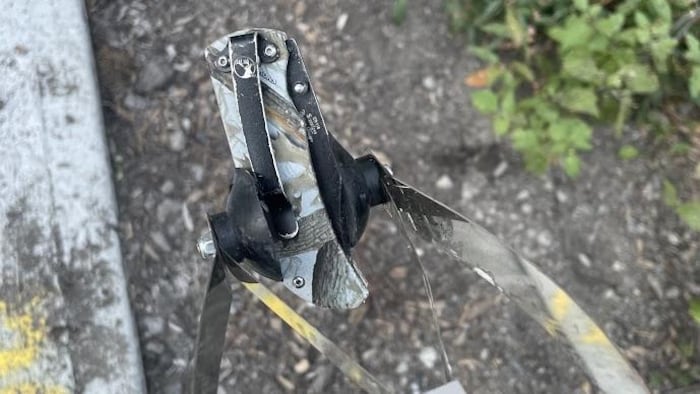 Une pince métallique tient un couteau de chasse.