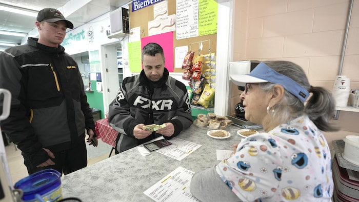 Deux hommes sont au comptoir pour acheter un repas. 