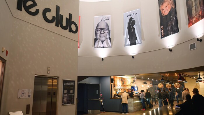 Intérieur du Club Dix30 montrant le comptoir du bar et des portraits géants de Simon Delisle, Souldia et Marjo au mur.