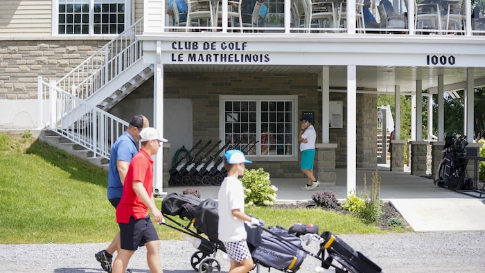 La devanture du club de golf avec des golfeurs qui marchent.
