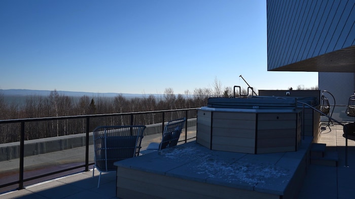 Des spas sur une terrasse en béton à l'extérieur. Un peu de neige est visible sur les marches