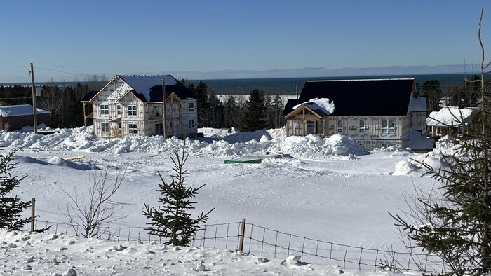 Deux édifices en construction dans un paysage hivernal. 