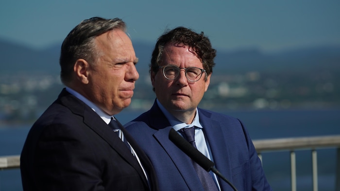 François Legault, l'air sérieux, tandis que Bernard Drainville le regarde.