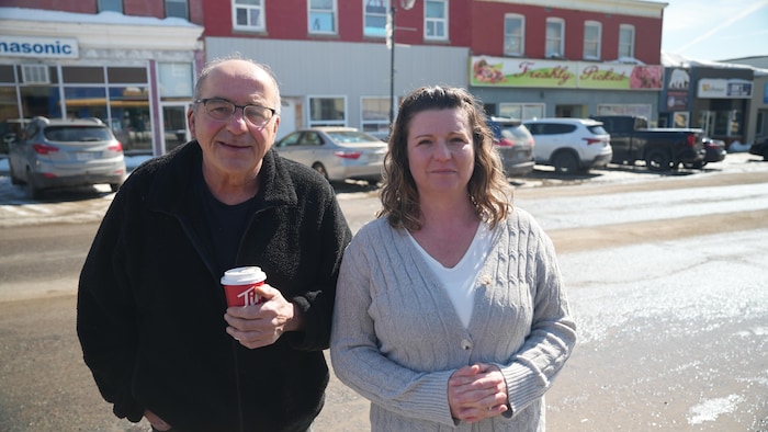 Un homme avec un café dans ses mains et une femme. 