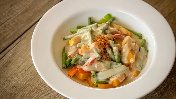 Vegan coconut ginger butternut squash na may long beans at bell pepper sa plato.