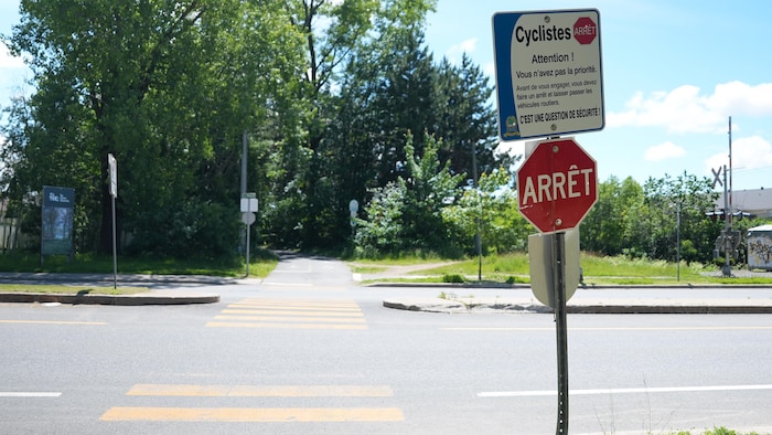 Une affiche et un panneau d'arrêt à une intersection.