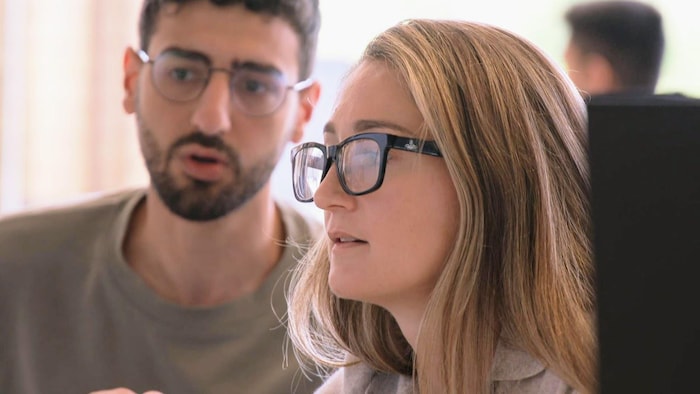 Liza Akhvledziani Carew devant un écran d'ordinateur avec un collègue.