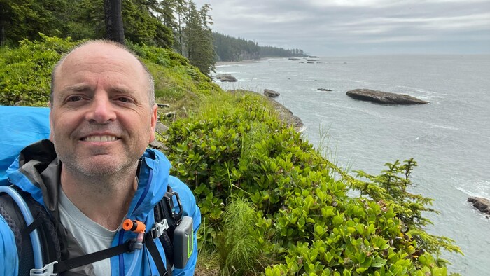 Colin Gartner sur le Sentier de la Côte-Ouest en 2025 devant l'océan.