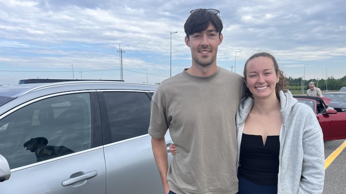 Colin Murney and his girlfriend are glued next to their vehicle. They are waiting for boarding the traveler.