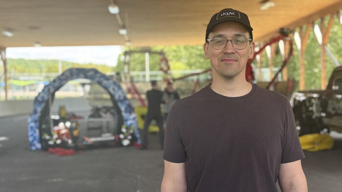 Un homme qui pose devant la caméra.