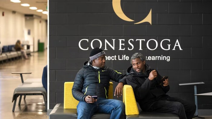 Deux étudiants devant un affichage du Collège Conestoga.