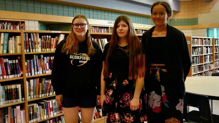 Rachel Spridzans, Mady Carrière et Janiq Chomini sont dans la bibliothèque de leur école.