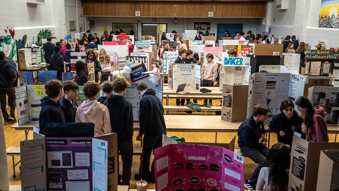 Un gymnase plein de cartons et élèves.