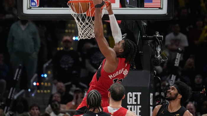 L’ailier des Raptors de Toronto, Collin Murray-Boyles (12), dunk devant le meneur des Cavaliers de Cleveland, Jaylon Tyson (à gauche), et le pivot Jarrett Allen (à droite), en deuxième mi-temps du match 7 du premier tour des séries éliminatoires de la NBA à Cleveland, le dimanche 3 mai 2026.