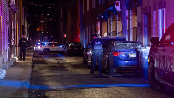 Un policier patrouille une rue la nuit.