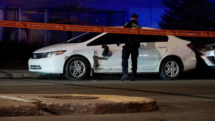 Un policier inspecte un véhicule.