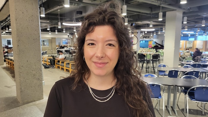 Une femme prend la pose pour la caméra lors d'un colloque à l'Université du Québec à Chicoutimi.