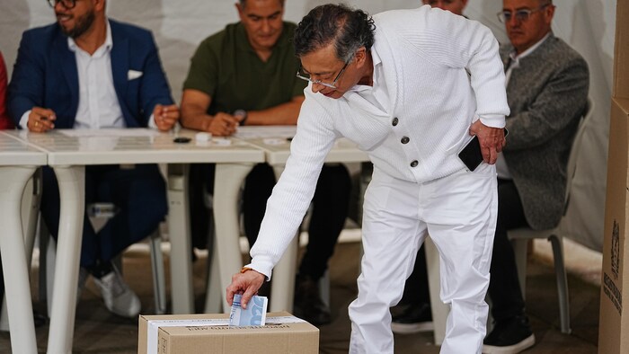 Gustavo Petro place son bulletin de vote dans une urne.