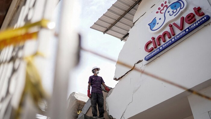 Un homme examine les dégâts dans un immeuble à Cali, le 14 août 2026.