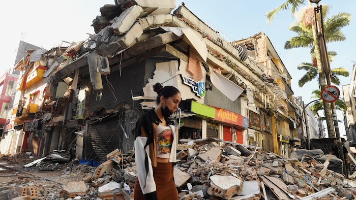 Une femme passe devant les décombres d'un immeuble effondré à Pereira.